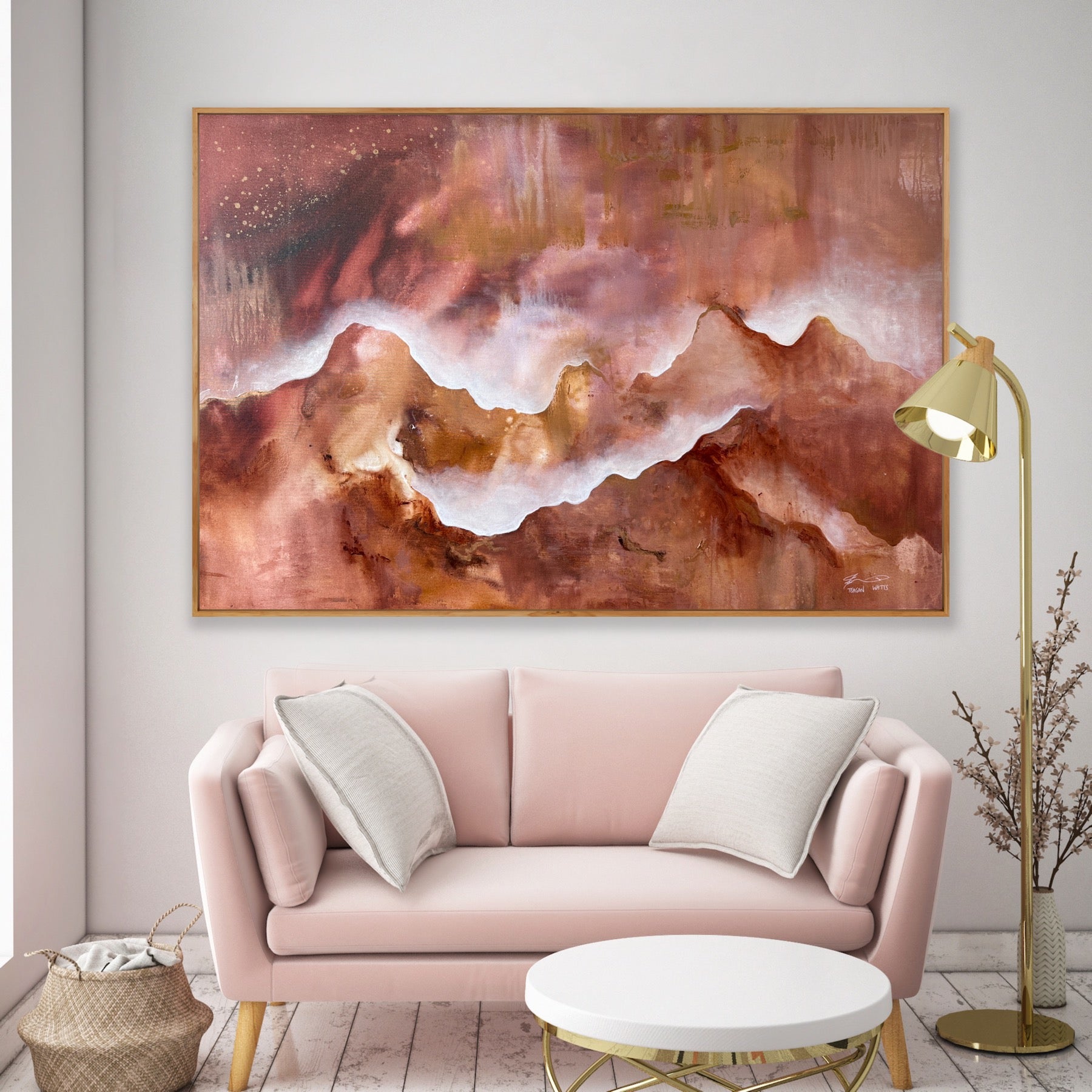Pink sofa with white cushions in a room with abstract art on the wall and a gold floor lamp.