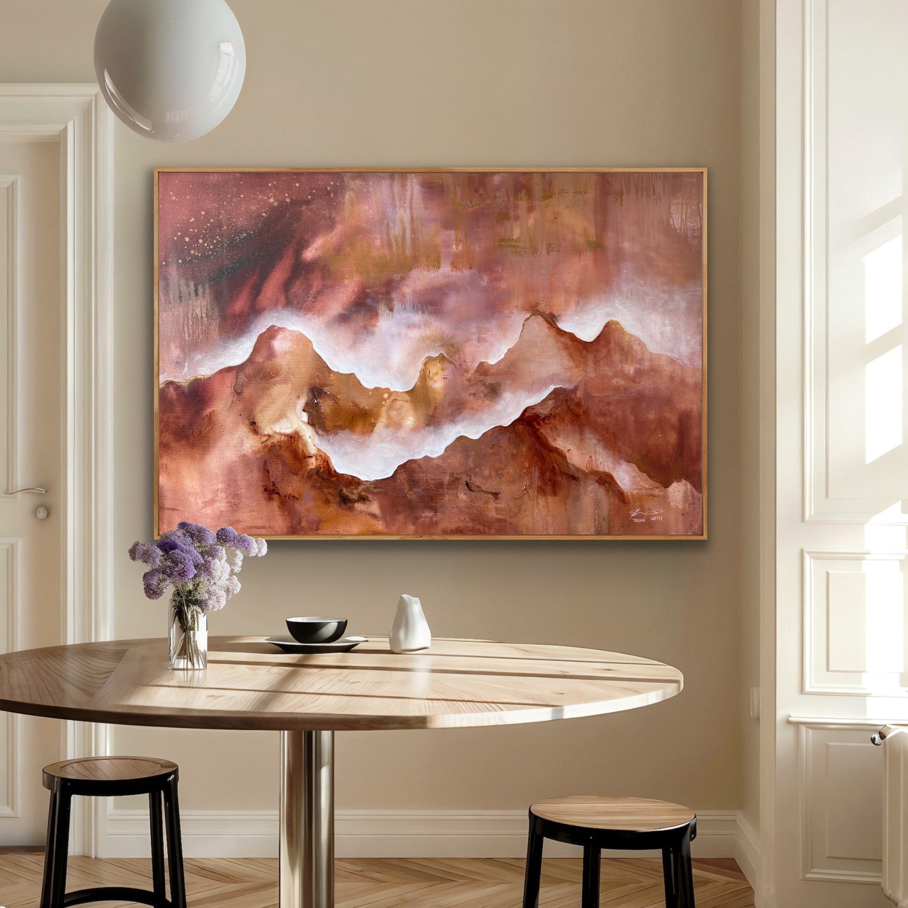 Abstract painting of a mountain on a wall above a dining table with decor items.
